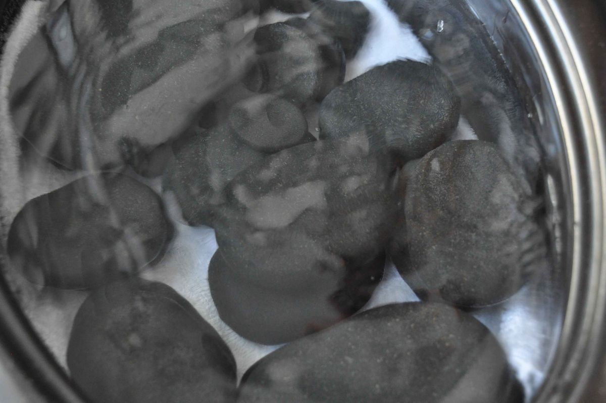 A bowl of smooth black massage stones